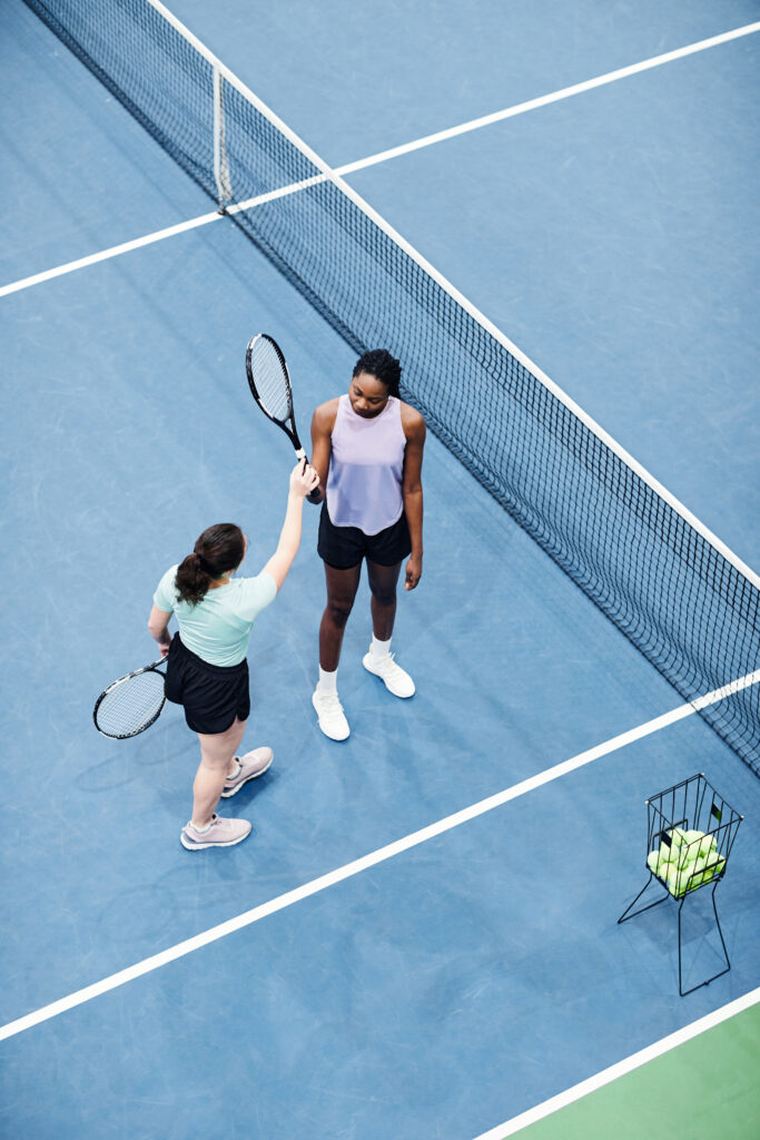 Vrouwelijke tennisspelers op een indoor tennisbaan